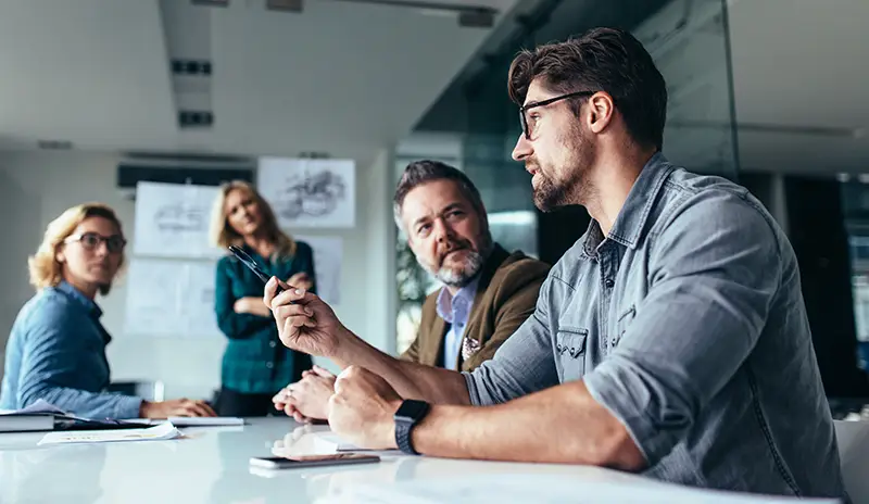 Le poids du réseau en temps de crise 1 Membres d’un réseau de franchise réunis autour d’une table pour discuter de stratégies pendant une période de crise